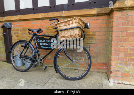 Black cycle with wicker carrying basket  the Great Eastern railway company at Wolferton station in Norfolk, England. Stock Photo