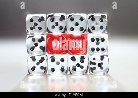 Win lose concept with two red dice supported in a wall of clear dice. Stock Photo