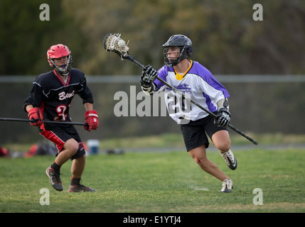 High school boys wear helmets while competing in a varsity lacrosse match in Austin, Texas. Stock Photo