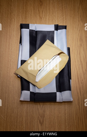 Chequered flag with a brown envelope full of money Stock Photo