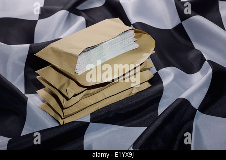 Chequered flag with brown envelopes full of money Stock Photo
