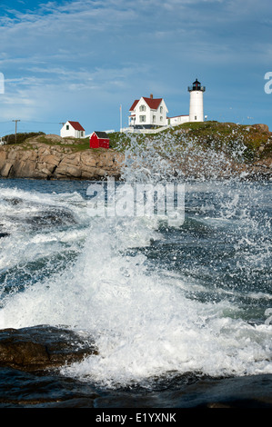 Dangerous surf at high tide by Nubble (Cape Neddick) lighthouse in Maine. Waves crashing on rocky shoreline. Stock Photo