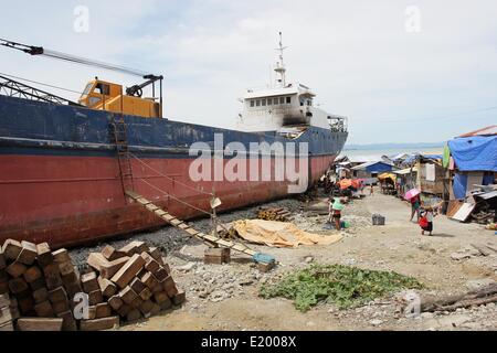 Tacloban City, Philippines. 11th June, 2014. A giant ship continues to lie within the community of Anibong in Tacloban City. On November 8, 2013, Haiyan, one of the most powerful typhoon to ever hit land, ravaged Eastern Visayas leaving thousands dead and homeless. Government estimates 16 million people to have been affected by the typhoon, with 6,300 reported dead and thousands more missing. Credit:  PACIFIC PRESS/Alamy Live News Stock Photo