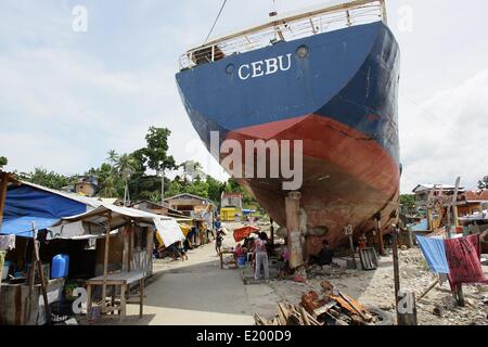 Tacloban City, Philippines. 11th June, 2014. A giant ship continues to lie within the community of Anibong in Tacloban City. On November 8, 2013, Haiyan, one of the most powerful typhoon to ever hit land, ravaged Eastern Visayas leaving thousands dead and homeless. Government estimates 16 million people to have been affected by the typhoon, with 6,300 reported dead and thousands more missing. Credit:  PACIFIC PRESS/Alamy Live News Stock Photo