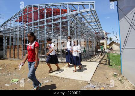 Tacloban City, Philippines. 11th June, 2014. Students walk past a school building going under construction in San Jose Central School, Tacloban City. On November 8, 2013, Haiyan, one of the most powerful typhoon to ever hit land, ravaged Eastern Visayas leaving thousands dead and homeless. Government estimates 16 million people to have been affected by the typhoon, with 6,300 reported dead and thousands more missing. Credit:  PACIFIC PRESS/Alamy Live News Stock Photo