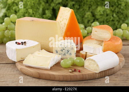 Cheese plate with Camembert, mountain and Swiss cheese on a wooden board Stock Photo