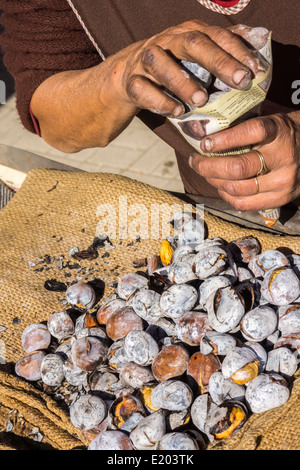 roasted chestnuts are being filled in a bag made of newspaper, aljustrel, alentejo, portugal Stock Photo