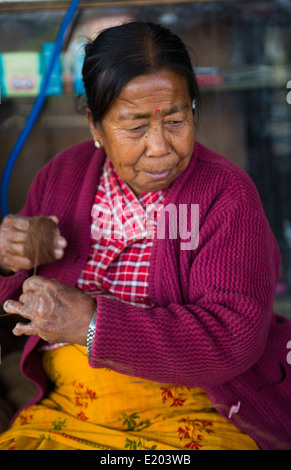 Kathmandu Nepal Nepali weaving woman posing and weaving threads for carpets in Nayapati, Eastern Kathmandu 42 Stock Photo