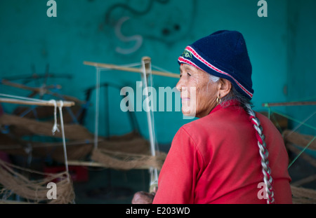 Nepal. Nepali weaving woman, posing and weaving threads for carpets. Nayapati, Eastern Kathmandu. 43 Stock Photo