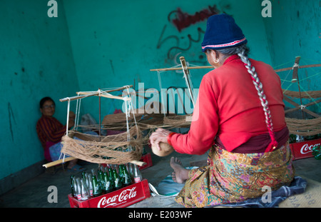 Nepal. Nepali weaving woman, posing and weaving threads for carpets. Nayapati, Eastern Kathmandu. 43 Stock Photo