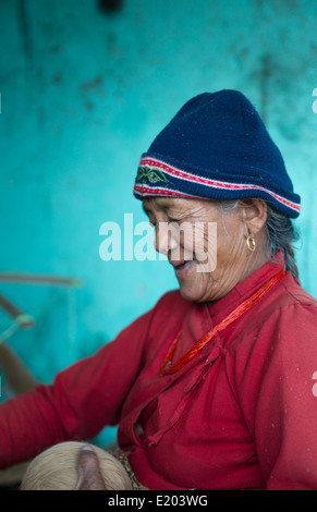 Nepal. Nepali weaving woman, posing and weaving threads for carpets. Nayapati, Eastern Kathmandu. 43 Stock Photo