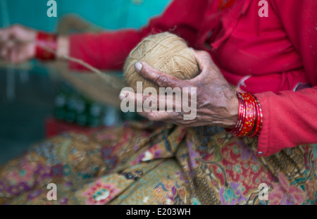 Nepal. Nepali weaving woman, posing and weaving threads for carpets. Nayapati, Eastern Kathmandu. 43 Stock Photo