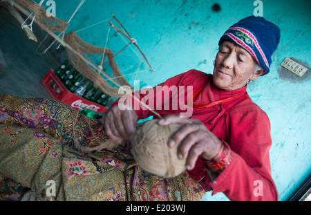 Nepal. Nepali weaving woman, posing and weaving threads for carpets. Nayapati, Eastern Kathmandu. 43 Stock Photo