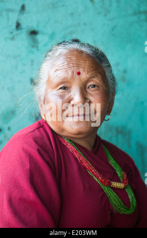 Nepal. Nepali weaving woman, posing and weaving threads for carpets. Nayapati, Eastern Kathmandu. 44 Stock Photo