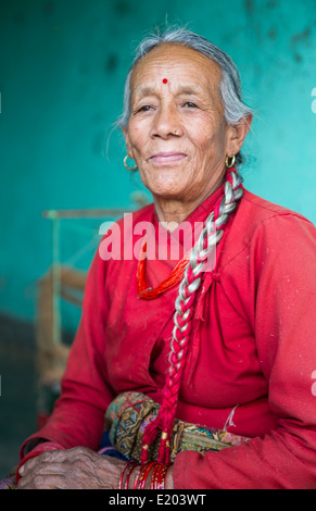 Nepal. Nepali weaving woman, posing and weaving threads for carpets. Nayapati, Eastern Kathmandu. 43 Stock Photo