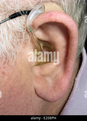 Elderly man wearing a digital hearing aid Stock Photo