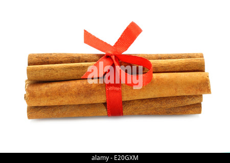 Bunch of cinnamon sticks with red bow on white background Stock Photo