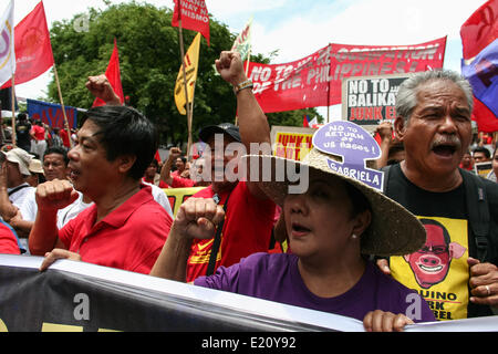 Manila, Philippines. 12th June, 2014. Protesters shout in anger against the alleged return of the US bases through the Enhanced Defense Cooperation Agreement between the Philippines and the US military. Several hundred protesters held different protest rallies all over Metro Manila marking the Philippines' 116th Independence Day. Different groups called for accountability and transparency regarding the corruption scandals of high ranking government officials. Credit:  PACIFIC PRESS/Alamy Live News Stock Photo