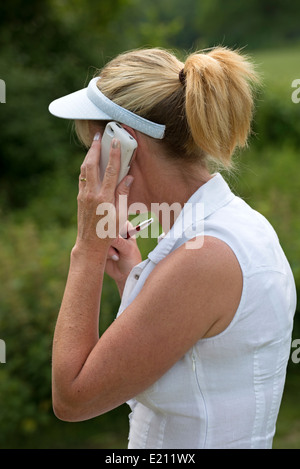 Woman using a mobile phone held to her ear a side view Stock Photo