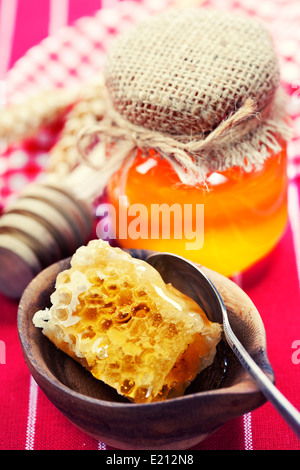 Beautiful honey comb, spoon and honey in jar Stock Photo