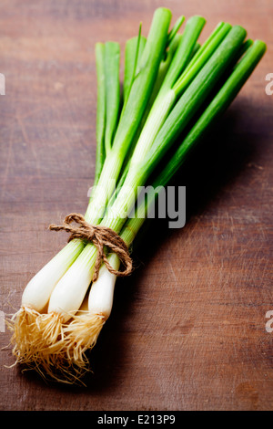 fresh spring onions on a wooden board Stock Photo