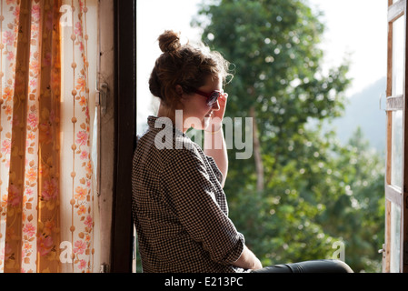 Woman sitting in a window admiring view Stock Photo