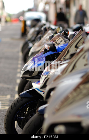 a row of parked sports motorbikes on street Stock Photo