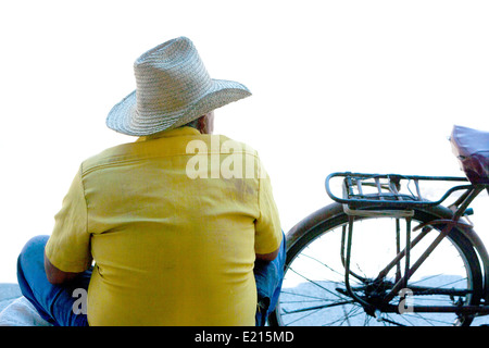Back of a Latino male wearing a straw hat with a bicycle Stock Photo