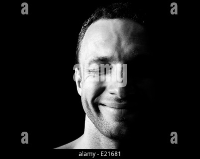 Young smiling Caucasian man portrait on black background