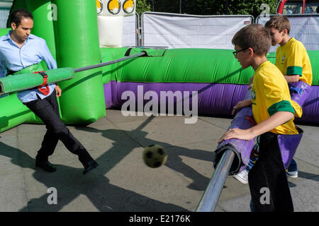 London, UK. 12th June, 2014. To celebrate the kick off of the 2014 World Cup Trafalgar Square in London hosted Brazil Day, a festival of Brazilian culture. Visitors had the opportunity to experience Brazilian dance, music, football and food. Pictured. Football fans get in on the action with a game of giant table football. Credit:  mark phillips/Alamy Live News Stock Photo