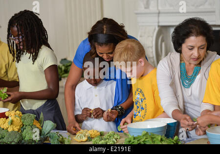 Washington, USA. 12th June, 2014. U.S. first lady Michelle Obama (2nd L) makes lunch with local students at the White House in Washington June 12, 2014. U.S. first lady Michelle Obama and local students who helped plant vegetables at the White House garden in early April made a lunch from this year's summer crop with the help of White House chefs and visiting school nutrition directors from Orlando, Dallas, and West Virginia on Thursday. Credit:  Bao Dandan/Xinhua/Alamy Live News Stock Photo