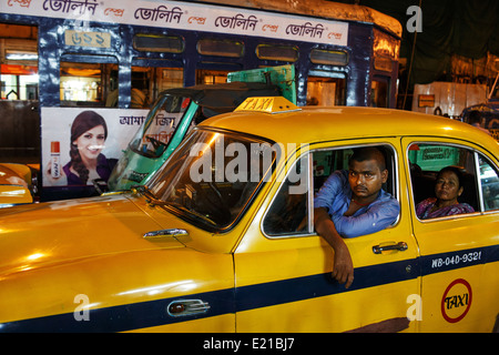 A taxi driver and his yellow Ambassador car stuck in a traffic jam in central Kolkata (Calcutta) India. Stock Photo