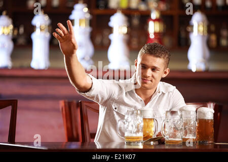Drunk man with a beer beckons the waiter Stock Photo