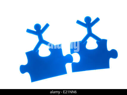 Two people rise hands on top of puzzles Stock Photo