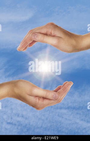 female hands over blue sky with clouds Stock Photo