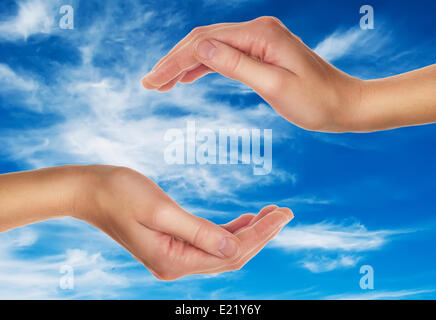 female hands over blue sky with clouds Stock Photo