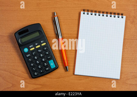 Calculator, notepad and pen on table. Stock Photo