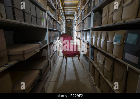 Empty Chair In Warehouse Aisle With Boxes On Shelves Stock Photo