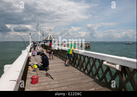 Families fishing off of Yarmouth pier on the Isle of Wight, England. Stock Photo