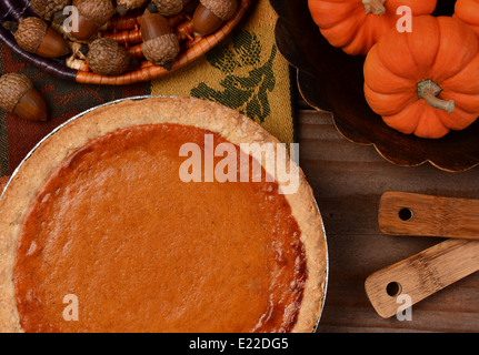 Overhead view of a fresh baked pumpkin pie ready for Thanksgiving. The pie is surrounded by autumn accessories Stock Photo