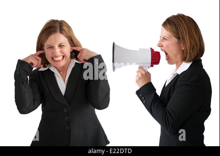 female employee being yelled or shouted at by female businesswoman manager using a loudhailer or megaphone isolated on white Stock Photo