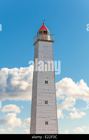 Tall gray lighthouse tower with red light and top Stock Photo