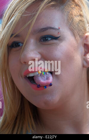 A young woman showing tongue piercing at the annual LGBT Tel Aviv pride parade also called 'Love Parade' as part of the international observance of Gay Pride Month. Israel Stock Photo