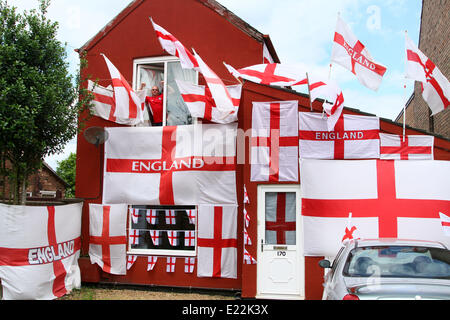 England fan . . Whittlesey, Cambridgeshire, UK . . 11.06.2014 Paul Skutela poses proudly with his house decorated in England flags, at Whittlesey, Cambridgeshire. Paul is a delivery driver and first decorated his house with flags during the 2006 World Cup and he has added more and more flags to his collection. A huge Arsenal, he is going to leave the flags in place, even if England get knocked out of the competition. Pic: Paul Marriott Photography Stock Photo