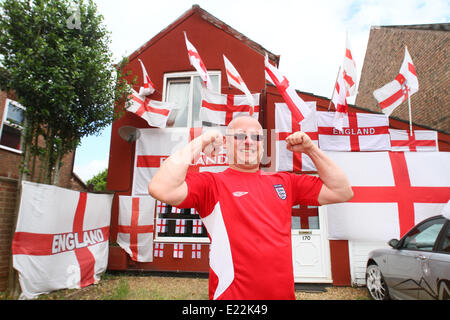 England fan . . Whittlesey, Cambridgeshire, UK . . 11.06.2014 Paul Skutela poses proudly with his house decorated in England flags, at Whittlesey, Cambridgeshire. Paul is a delivery driver and first decorated his house with flags during the 2006 World Cup and he has added more and more flags to his collection. A huge Arsenal, he is going to leave the flags in place, even if England get knocked out of the competition. Pic: Paul Marriott Photography Stock Photo