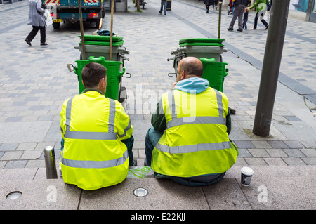 Two council workers who do street sweeping, having a coffee break. Sauchiehall Street, Glasgow, Scotland, UK Stock Photo