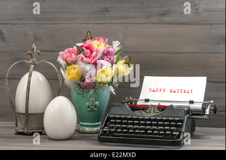 Easter still life with tulips, eggs and antique typewriter. Sample text Happy Easter! Stock Photo