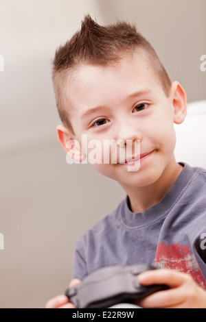 Kid having fun with video games in a brighly lit living room Stock Photo
