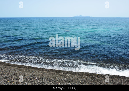 The beach with black volcanic stones at Santorini island, Greece Stock Photo