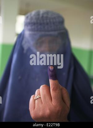 Kabul, Afghanistan. 14th June, 2014. A woman shows her inked finger after casting her vote at a polling station in Kabul, Afghanistan, on June 14, 2014. Polls opened Saturday morning in Afghan presidential election runoff, with Election Commission Chairman Ahmad Yusuf Nuristani being the first to cast his vote to elect the country's next president. Credit:  Ahmad Massoud/Xinhua/Alamy Live News Stock Photo